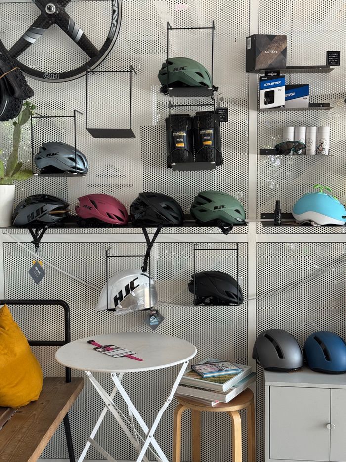 A variety of colorful bicycle helmets displayed on a wall in a modern shop setting.