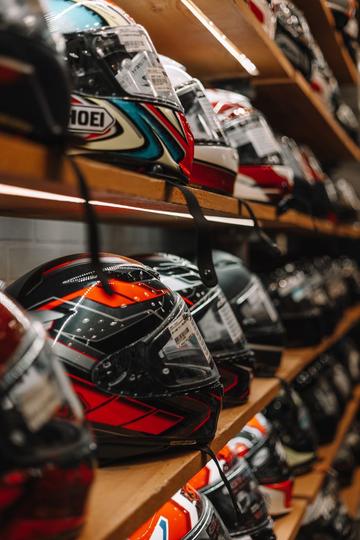 Vibrant array of motorcycle helmets neatly arranged on a shelf in a store.